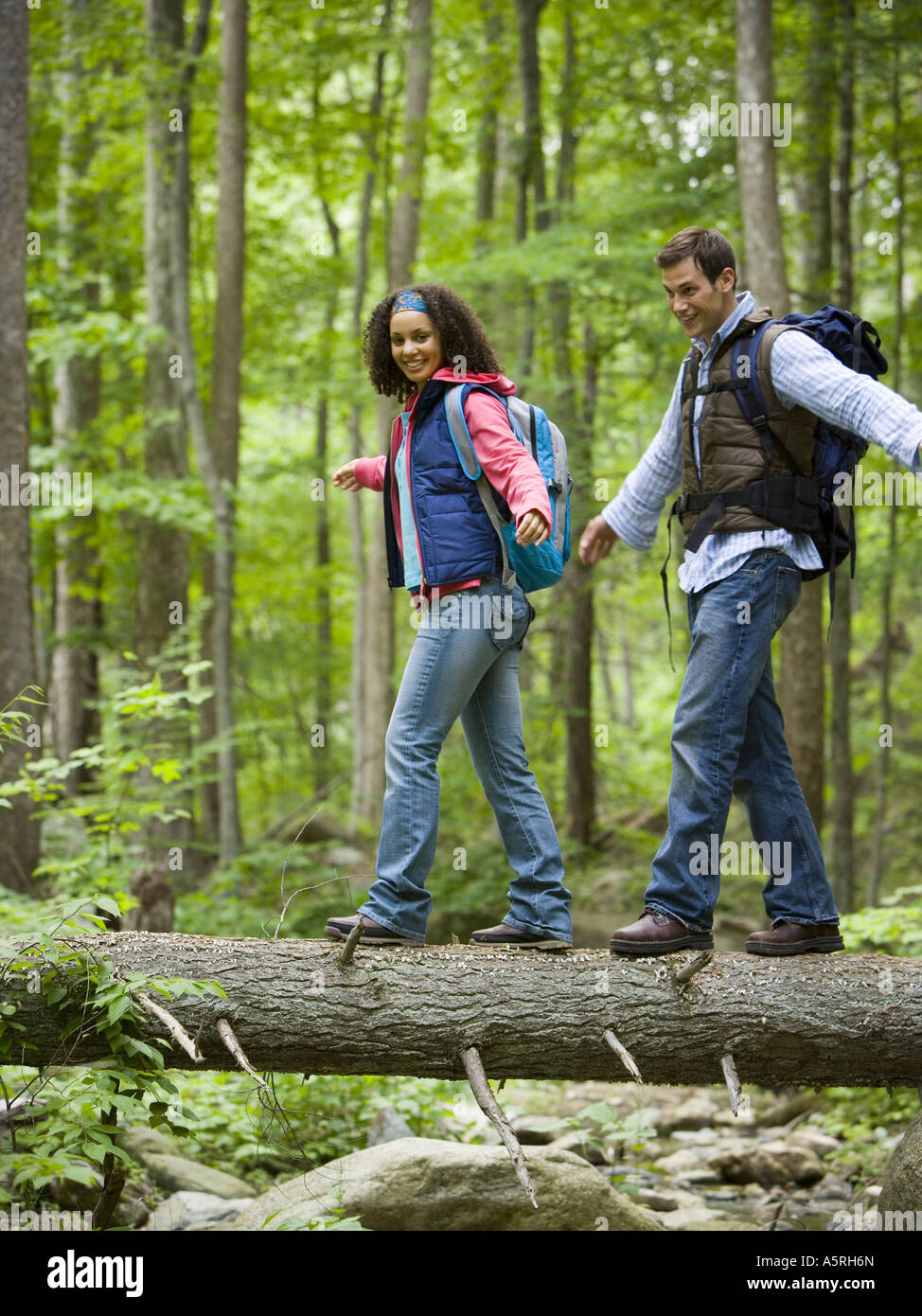 Niedrigen Winkel Blick auf ein junges Paar zu Fuß auf einen umgestürzten Baum Stockfoto