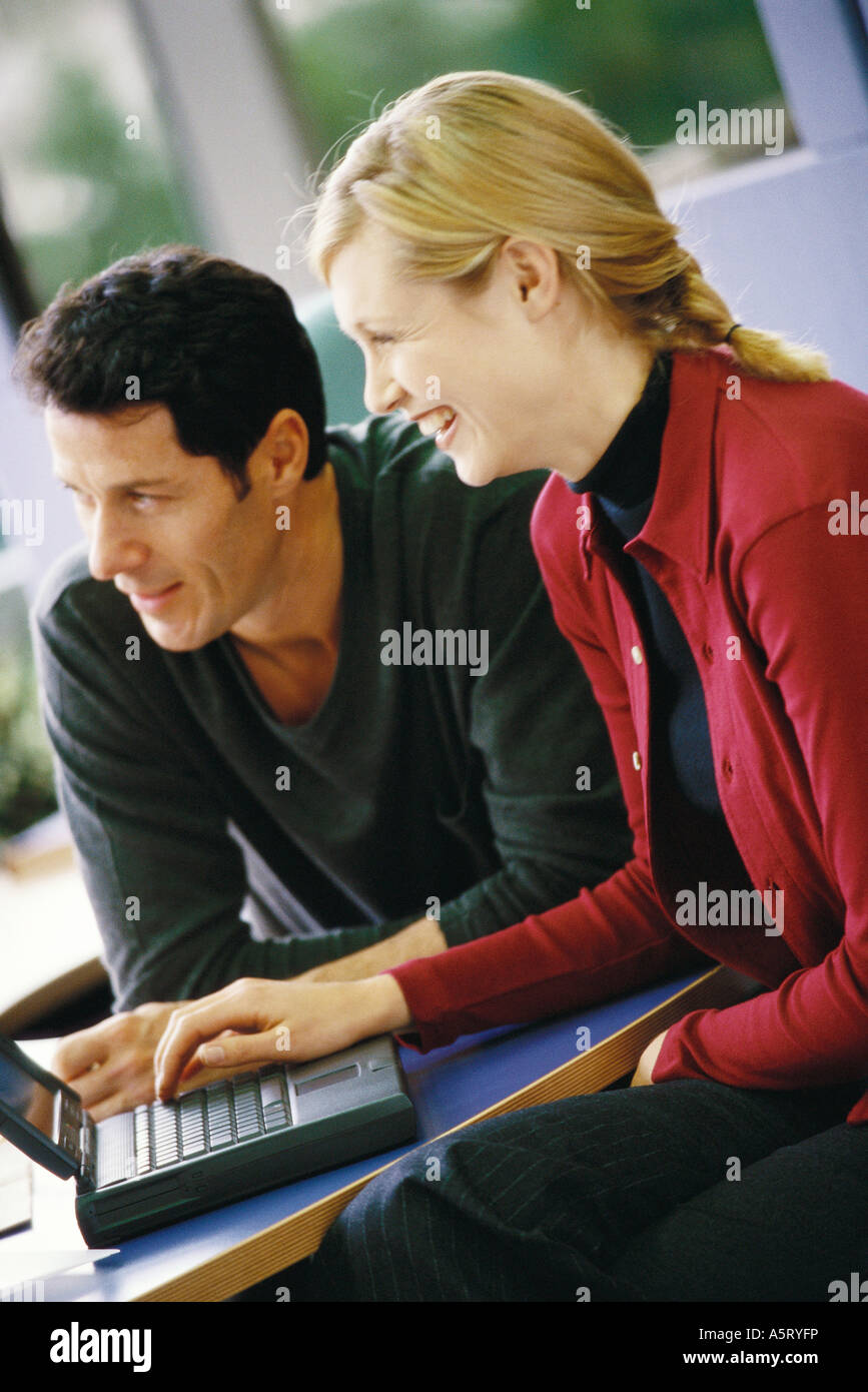 Mann und Frau mit Laptop, Lächeln, wegschauen Stockfoto
