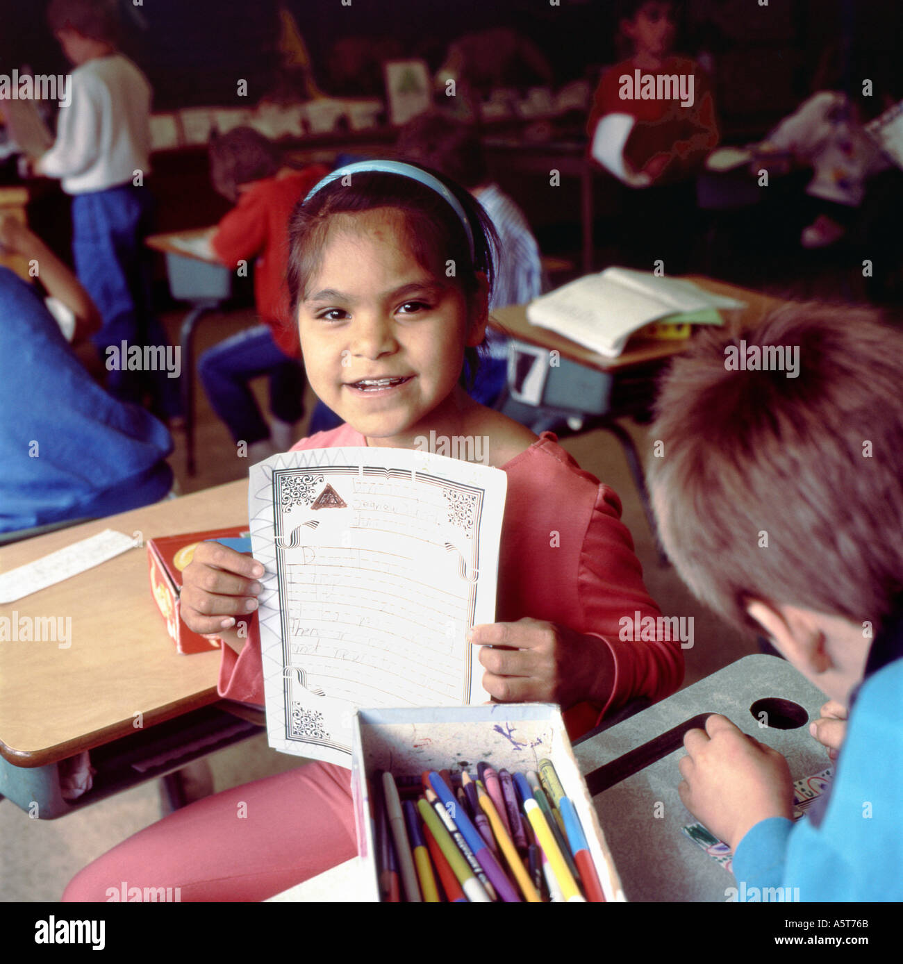 Ein Indianerin der Ureinwohner der First Nations lächelt und zeigt ihre Schularbeiten in einem Klassenzimmer auf Vancouver Island, British Columbia, Kanada, KATHY DEWITT Stockfoto