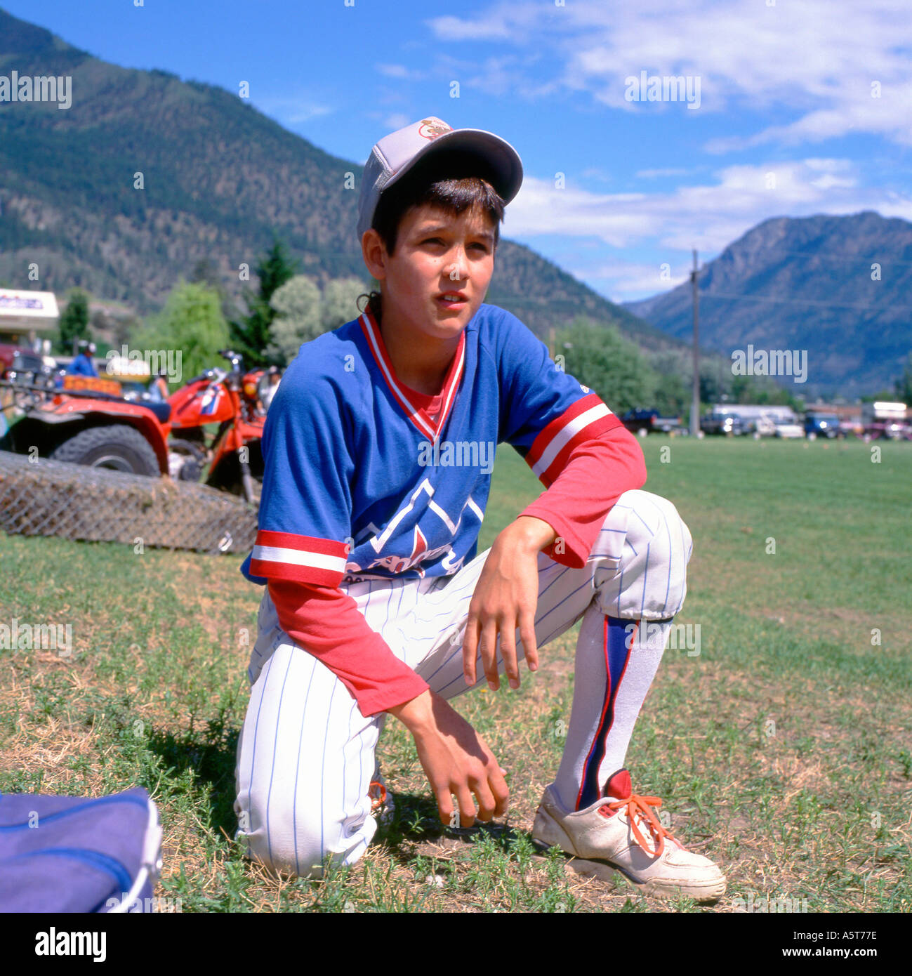 Ein Kanadischer Teenager-Junge Der First Nations, der eine Baseballkappe und einen einheitlichen Baseballspieler im Landscape Lillooet British Columbia Canada KATHY DEWITT trägt Stockfoto