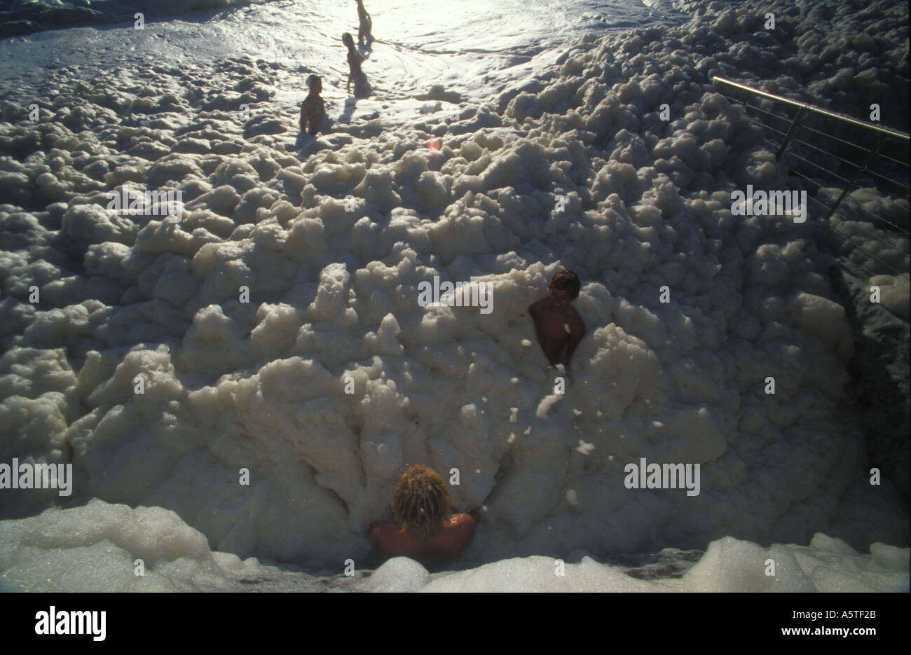 Kinder spielen im Meer Schaum Maroochydore Strand nach Sturm 3363 Stockfoto