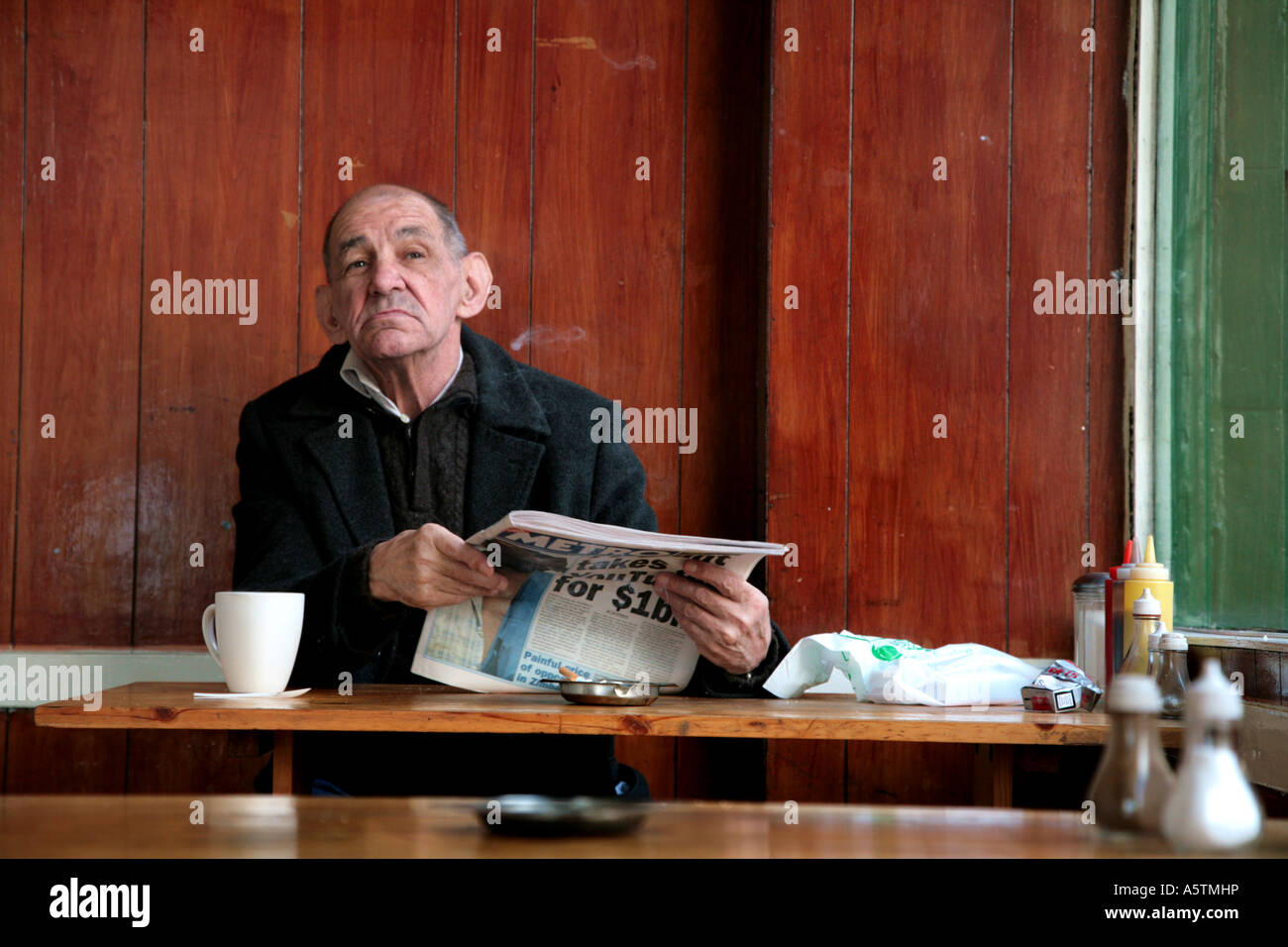 Mann im Café lesen Zeitung Stockfoto