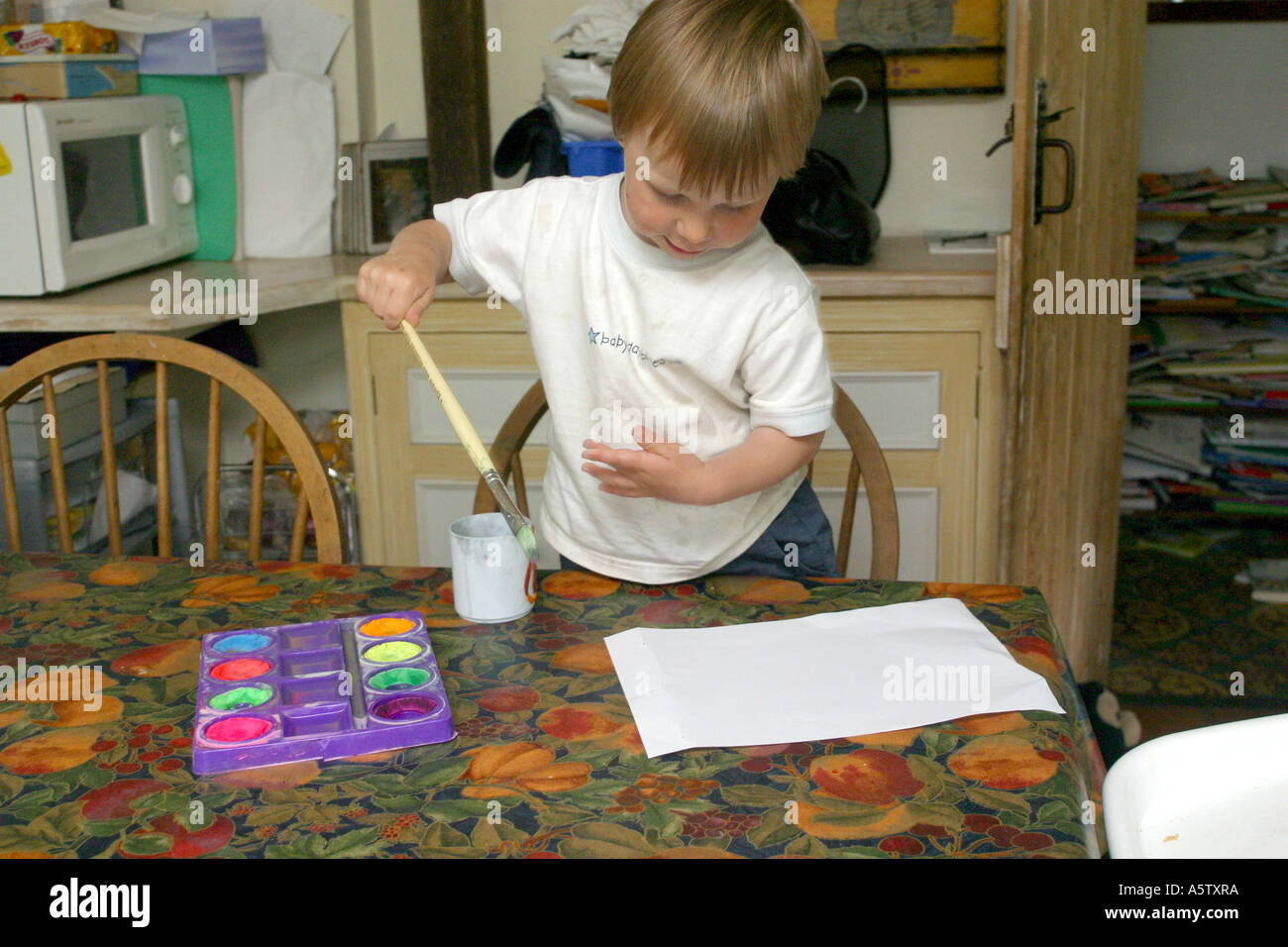 drei Jahre alter Junge ein Bild am Küchentisch Stockfoto