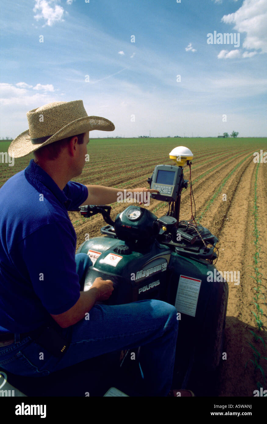 LANDWIRT IN FELD MIT MODERNER TECHNIK WIE ATV MIT GPS COMPUTER UND HANDY / TEXAS Stockfoto