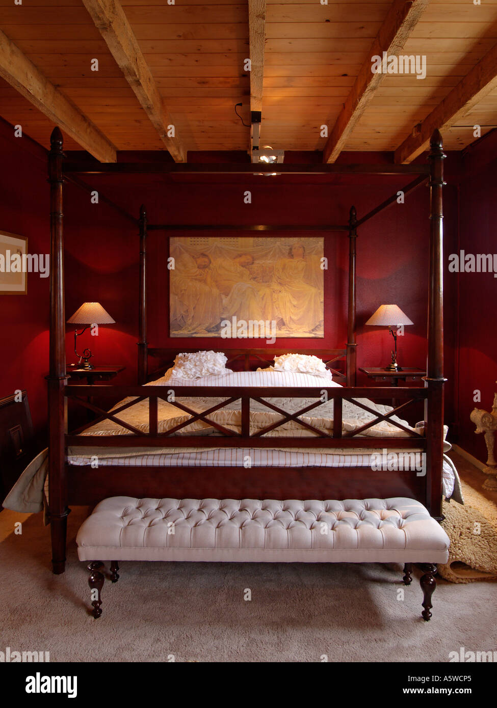 Stilvolle Schlafzimmer mit roten Wand Holzdecke und großen Himmelbett Stockfoto
