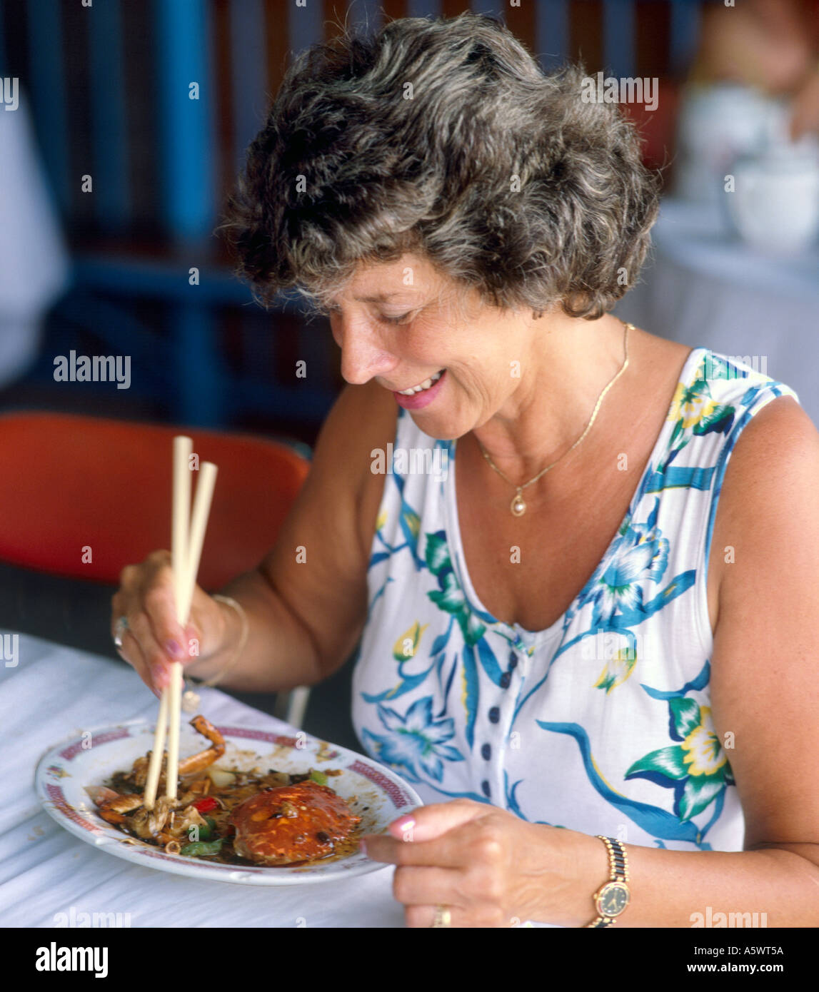 Frau Krabbe mit Stäbchen in einem Fischrestaurant auf Lamma Island in Hongkong essen, Stockfoto
