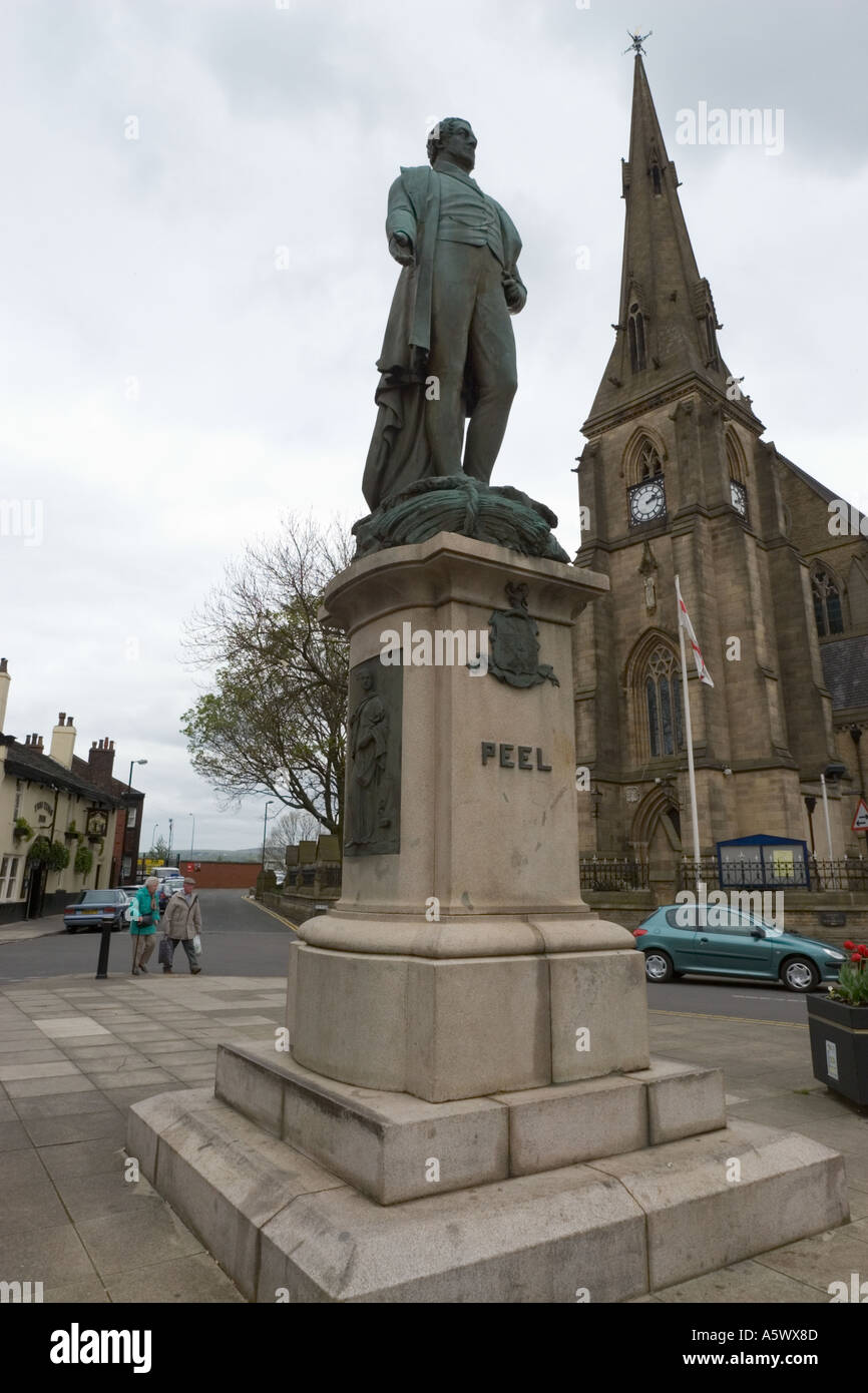Sir Robert Peel Statue auf dem Marktplatz, Bury Stadtzentrum mit Kirche im Hintergrund und bewölktem Himmel in lancashire uk Stockfoto