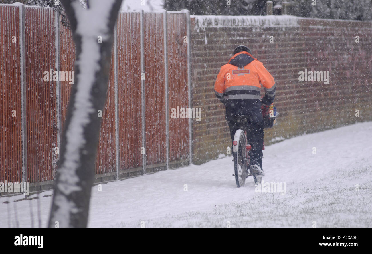 Postbote arbeitet hart an einem schneereichen Wintern Morgen England Stockfoto