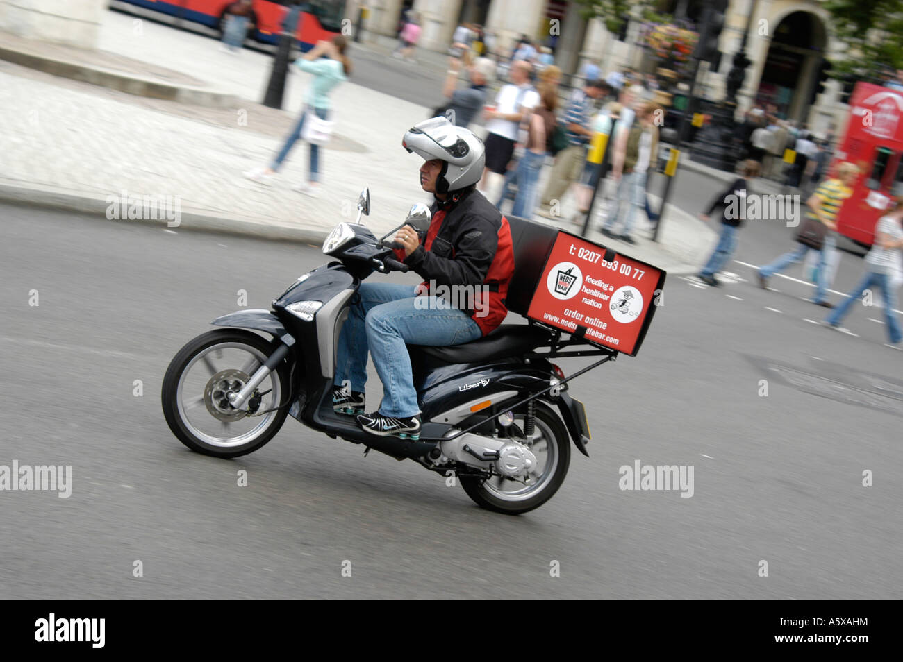 Bereitstellung von Nudeln auf einem Moped im Zentrum der City of london Stockfoto