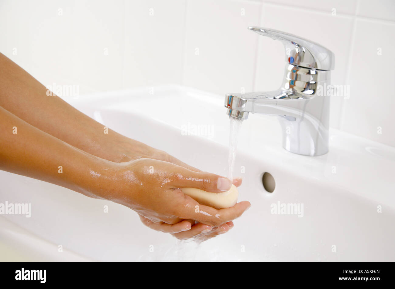 Frau, die Hände zu waschen Nahaufnahme mit bar Seife im Waschbecken Stockfoto