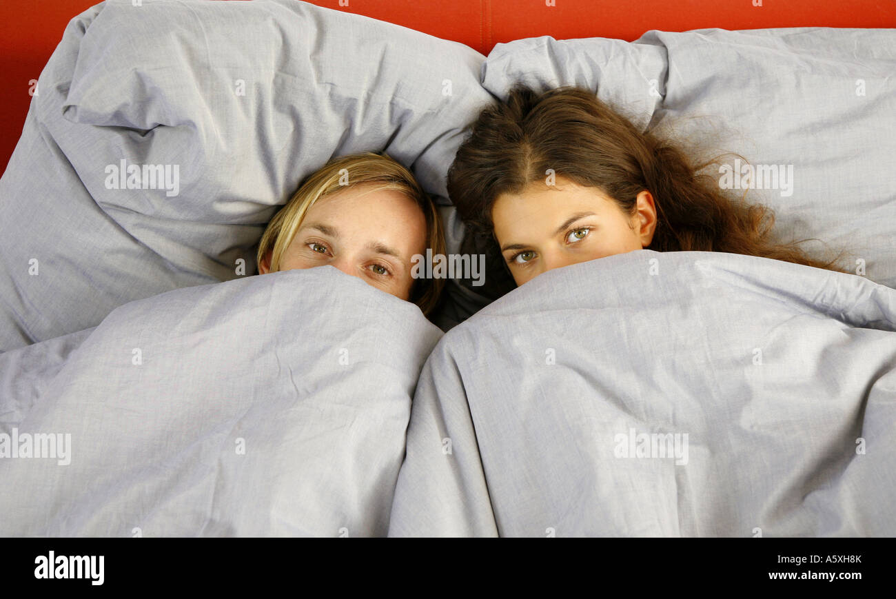 Junges Paar auf Bett Blick in die Kamera erhöht, Ansicht Stockfoto