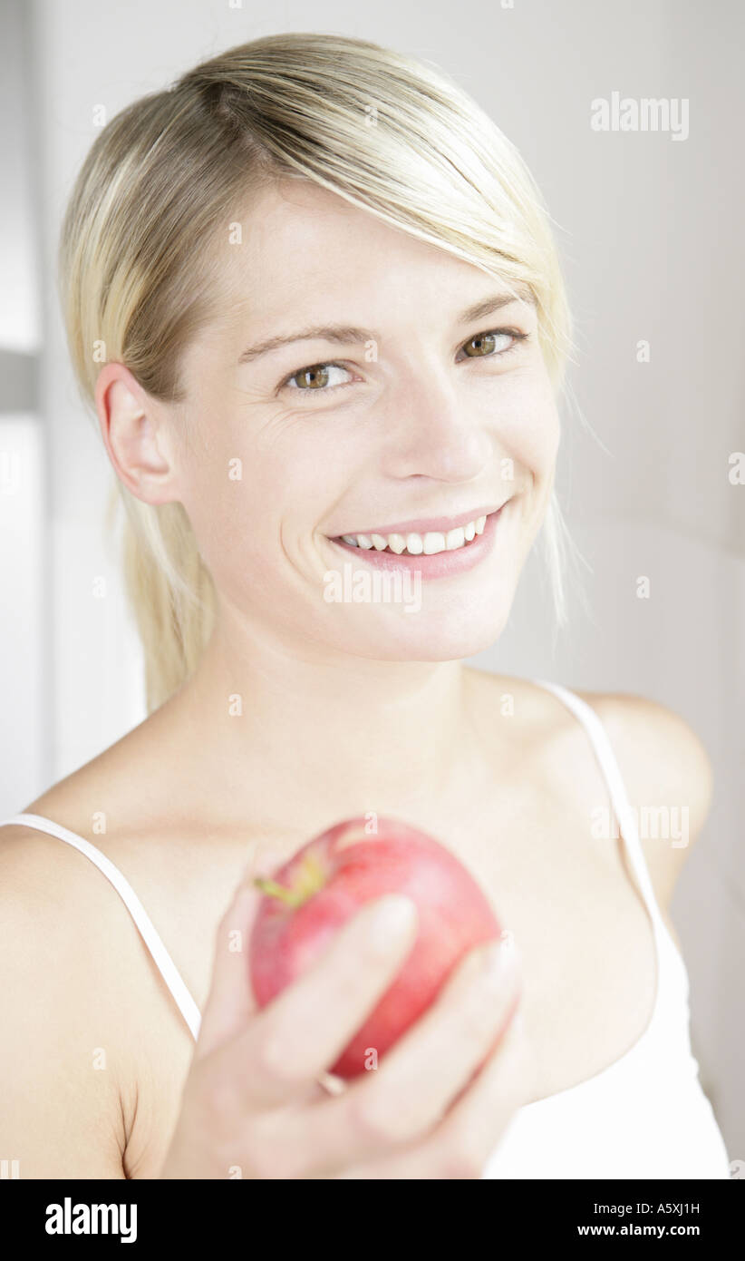 Junge Frau hält Apfel lächelnd Porträt hautnah Stockfoto