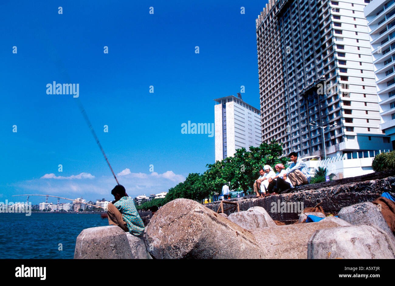 Nariman Point "Mumbais Manhattan". Ein Slumdweller Angeln zum Abendessen vor mondänen Hochhäuser und 5-Sterne-Hotel. Stockfoto