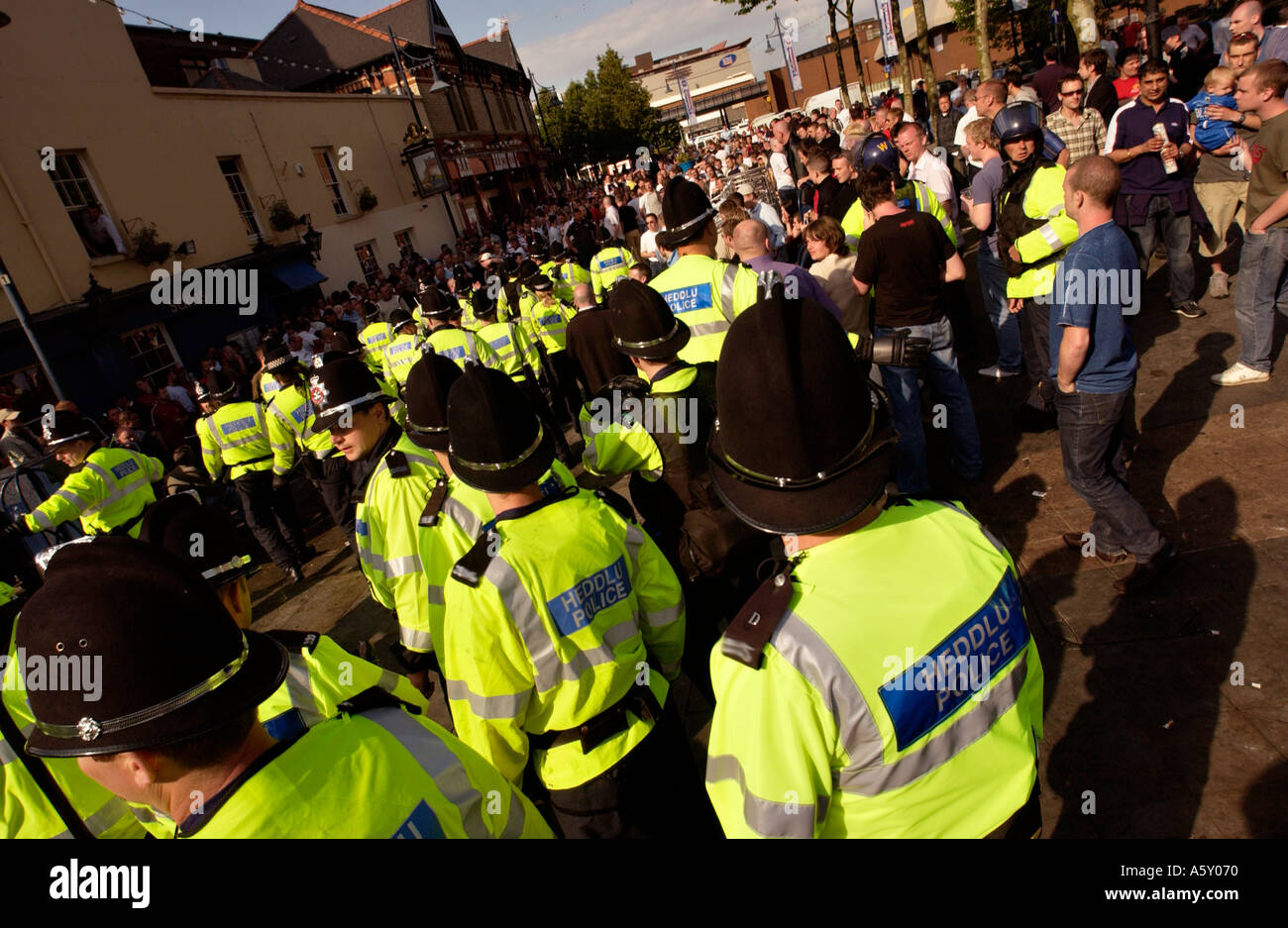 Polizisten ziehen Schlagstöcke bei Ärger unter den Fußball-Fußball-Fans trinken von Alkohol in Mill Lane Cardiff South Wales UK Stockfoto