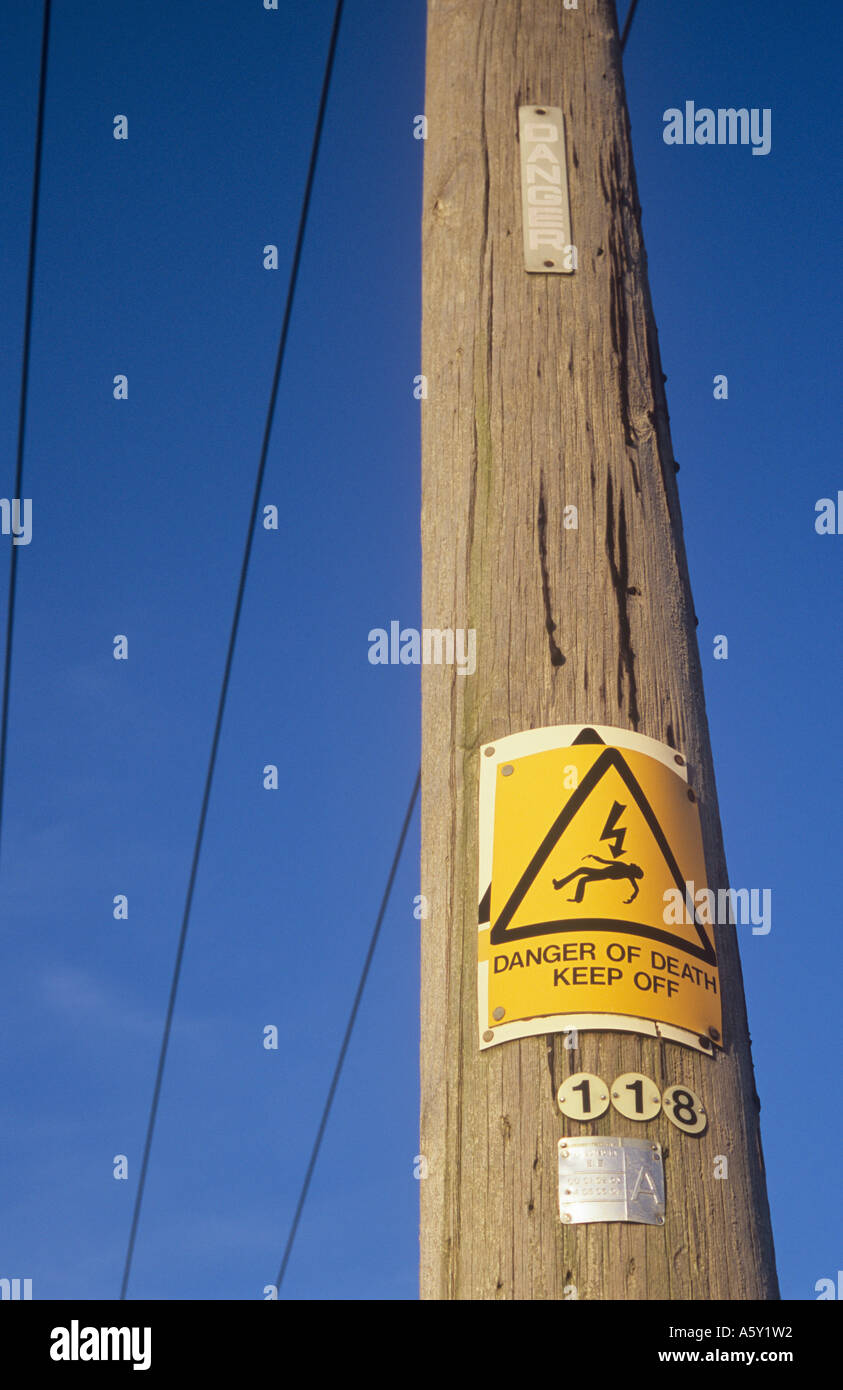 Gelbes Schild mit legendären Mann wird mit Elektroschocks und Worten Lebensgefahr fernzuhalten genagelt über ältere Zeichen an Elektrizität Mast Stockfoto
