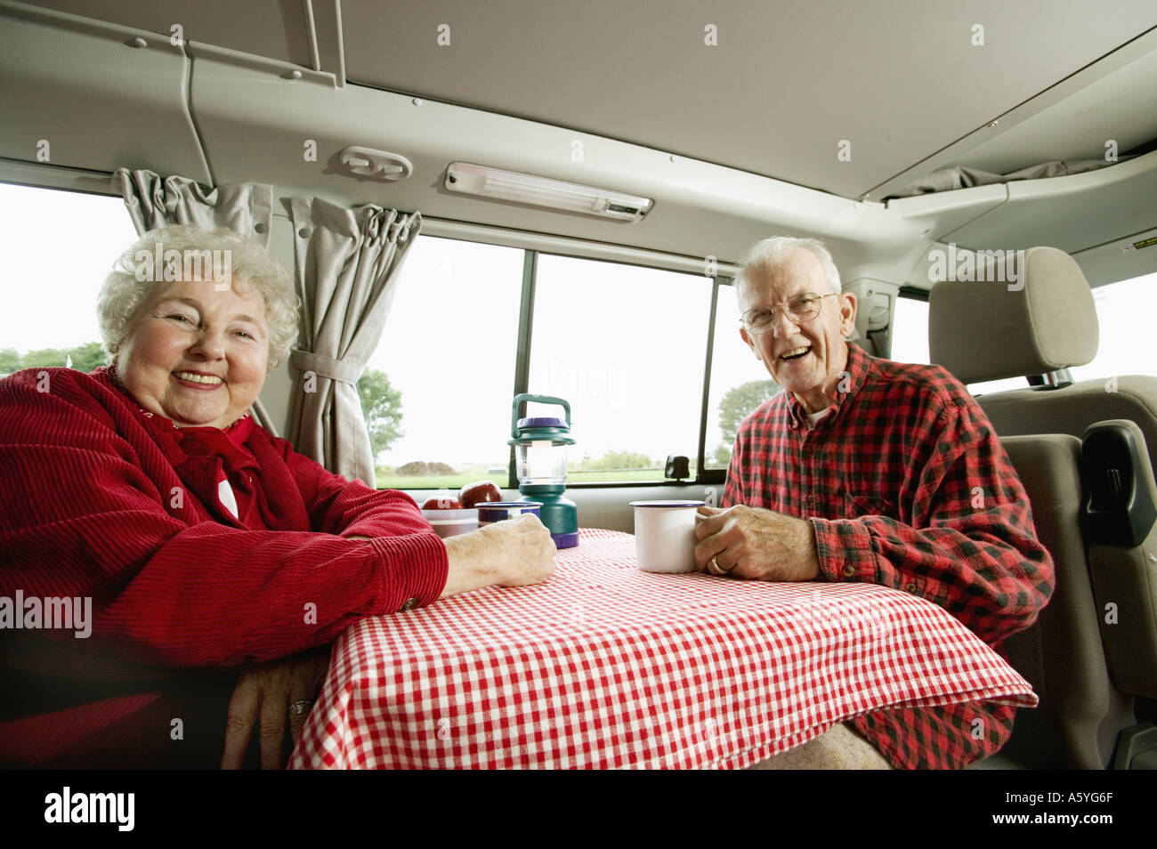 Älteres paar sitzen zusammen in ihrem van Stockfoto