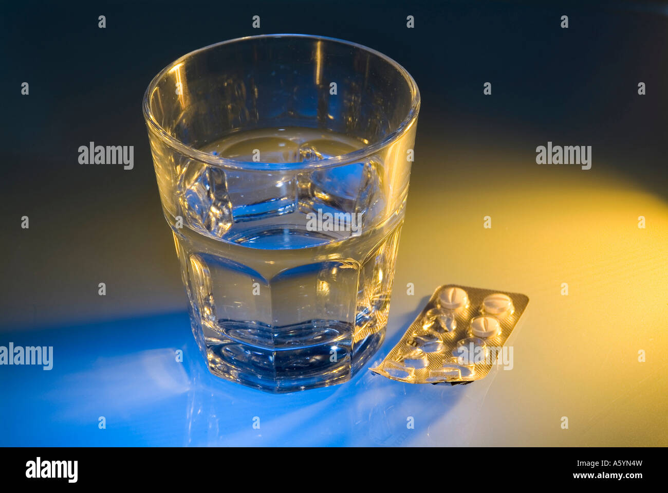 Verpackung von Tabletten unter ein Glas Wasser Stockfoto