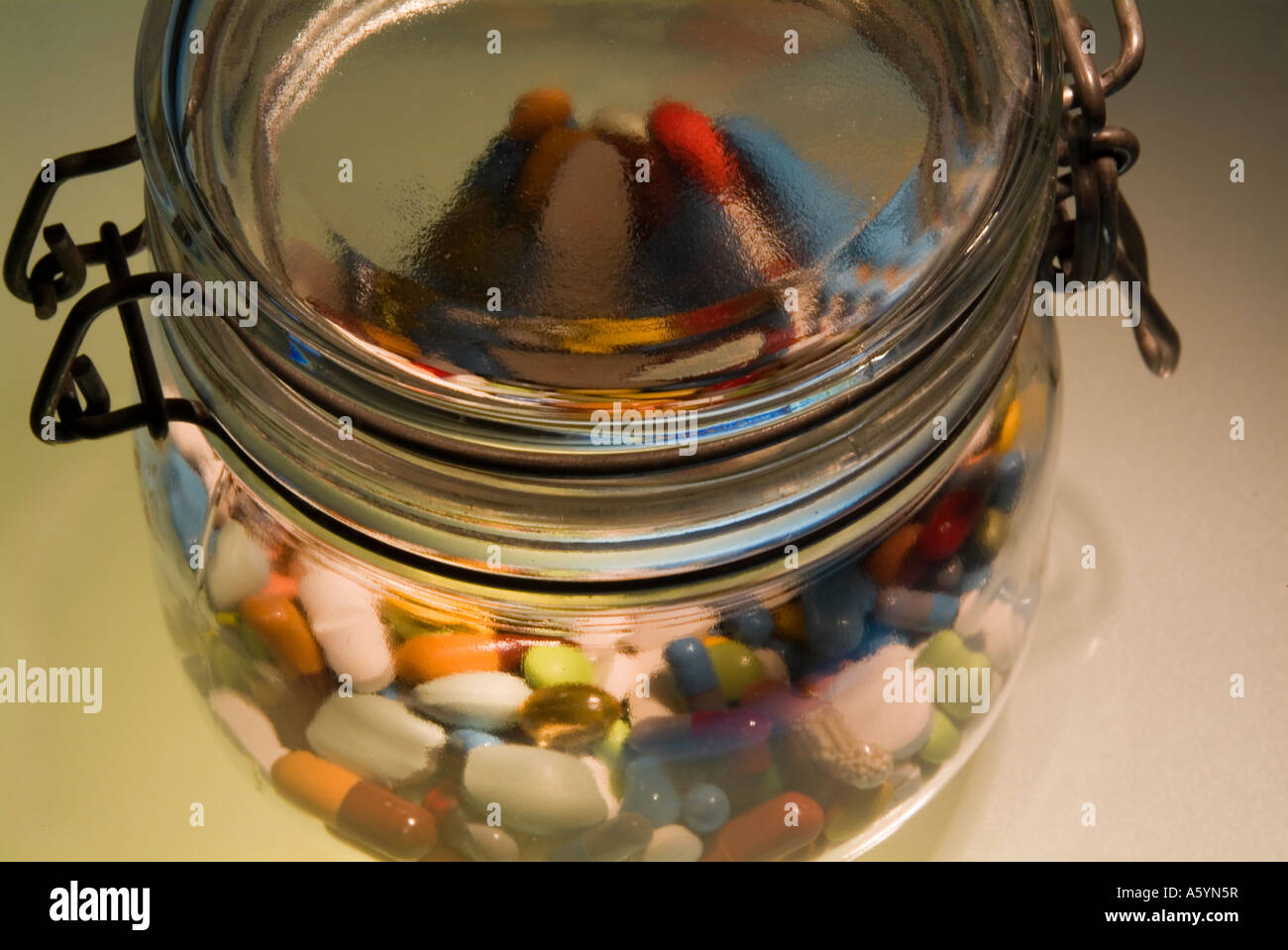 Pillen und Kapseln in verschiedenen Farben in einem konservierenden Glas-Glas Stockfoto