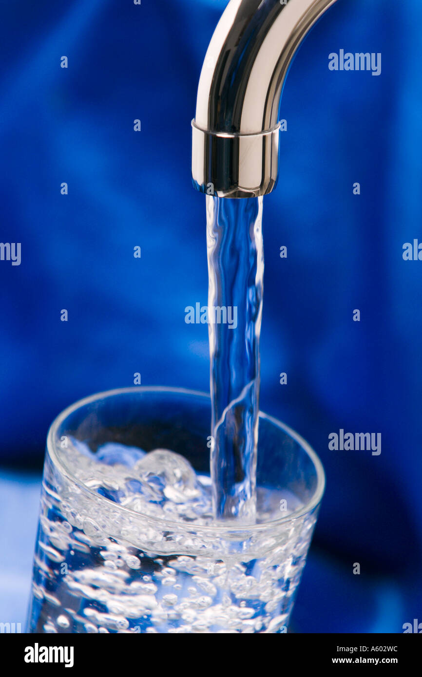 Wasser fließt aus Chrom Wasserhahn Glas klar Stockfoto
