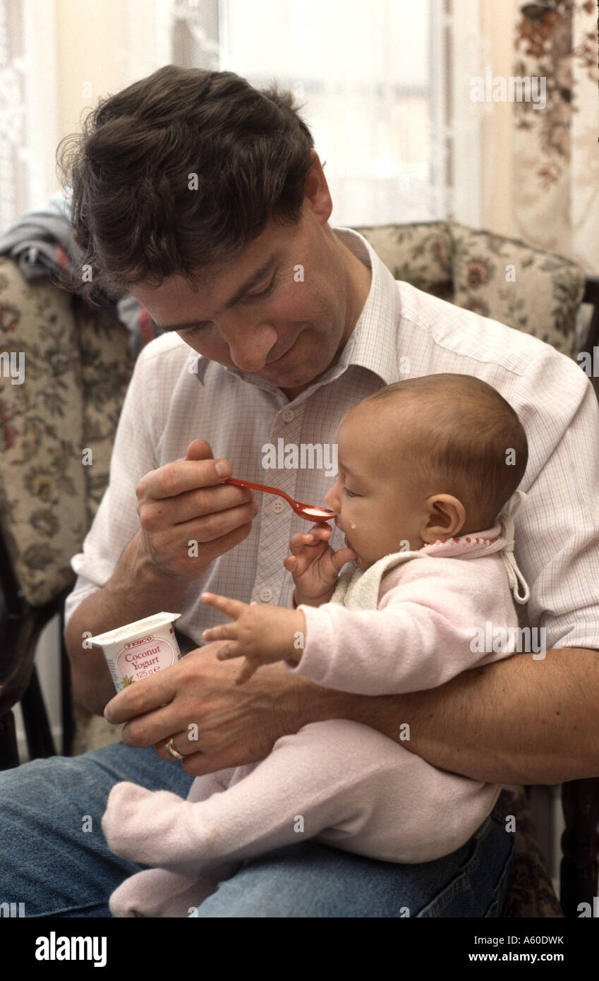 Vater Löffel Joghurt Baby füttern Stockfoto