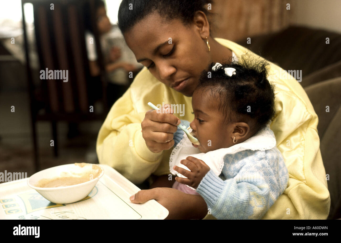 Schwarze Mutter Löffel füttern Baby Tochter Stockfoto