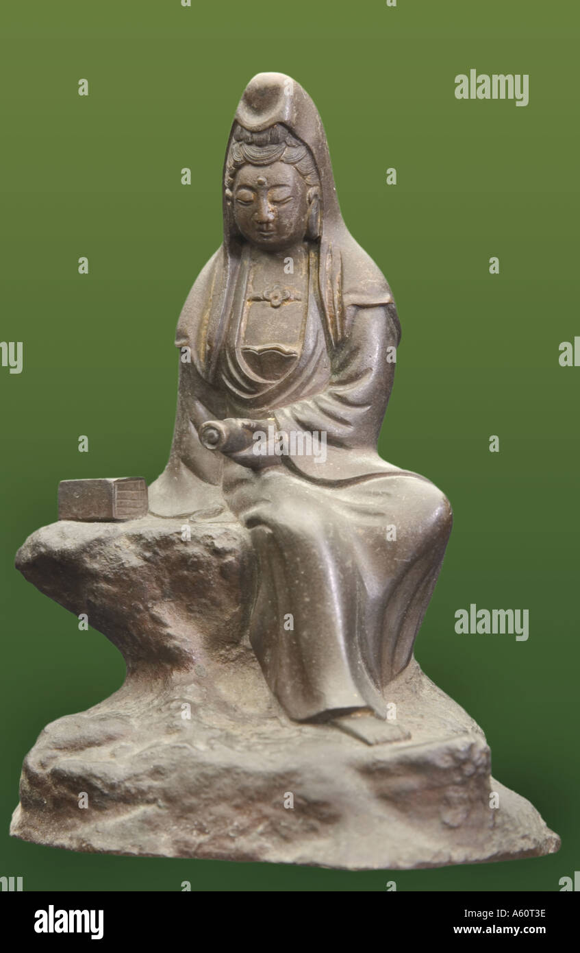 Statuette der Kuan Yin Holding eine Schriftrolle, während auf einem Felsen sitzt. Stockfoto