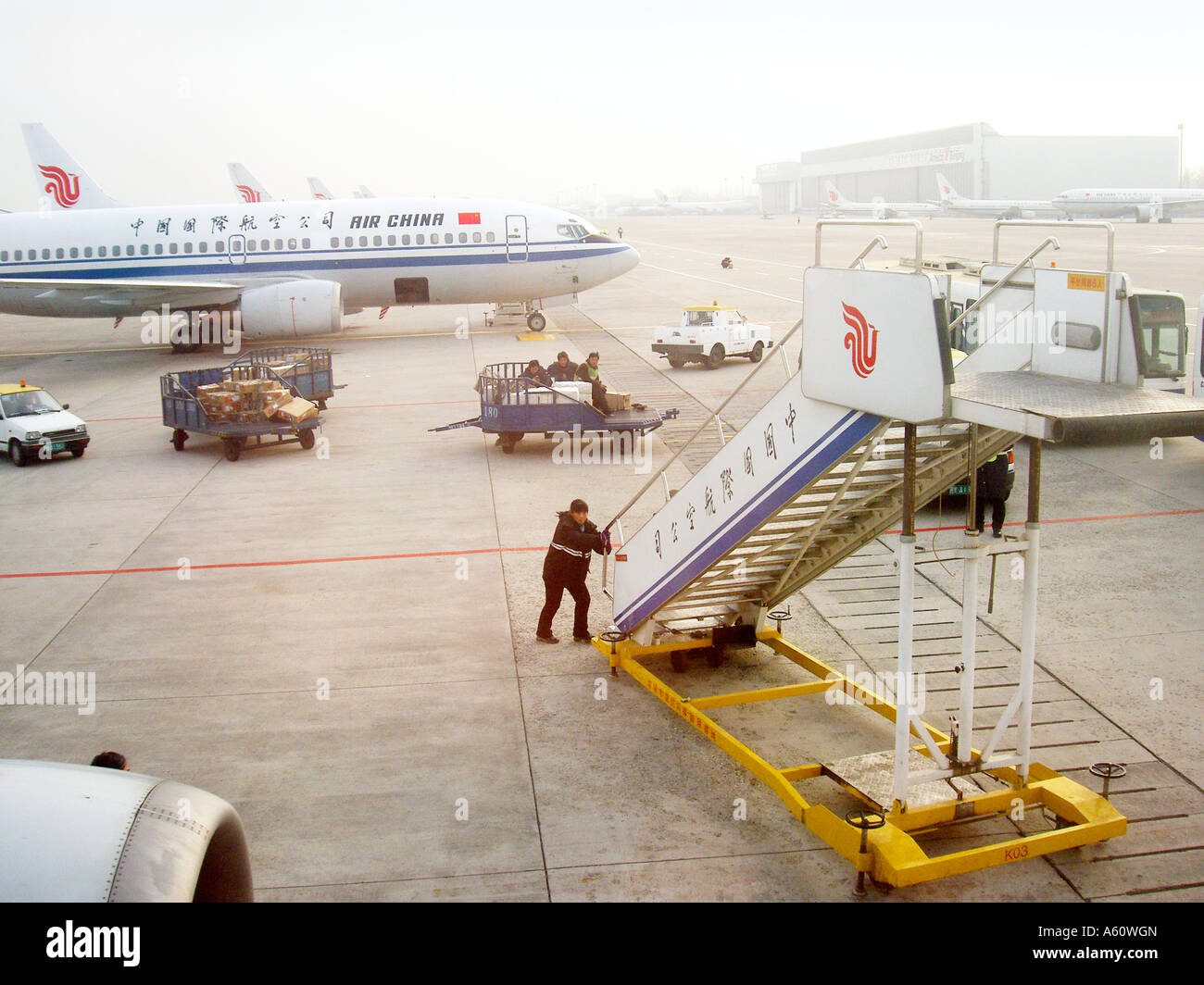 Flughafen Peking China. Air China chinesische Jet Flugzeug Passagierflugzeug auf terminal Schürze. Man nähert sich mit Ausfahrt Treppen Stockfoto