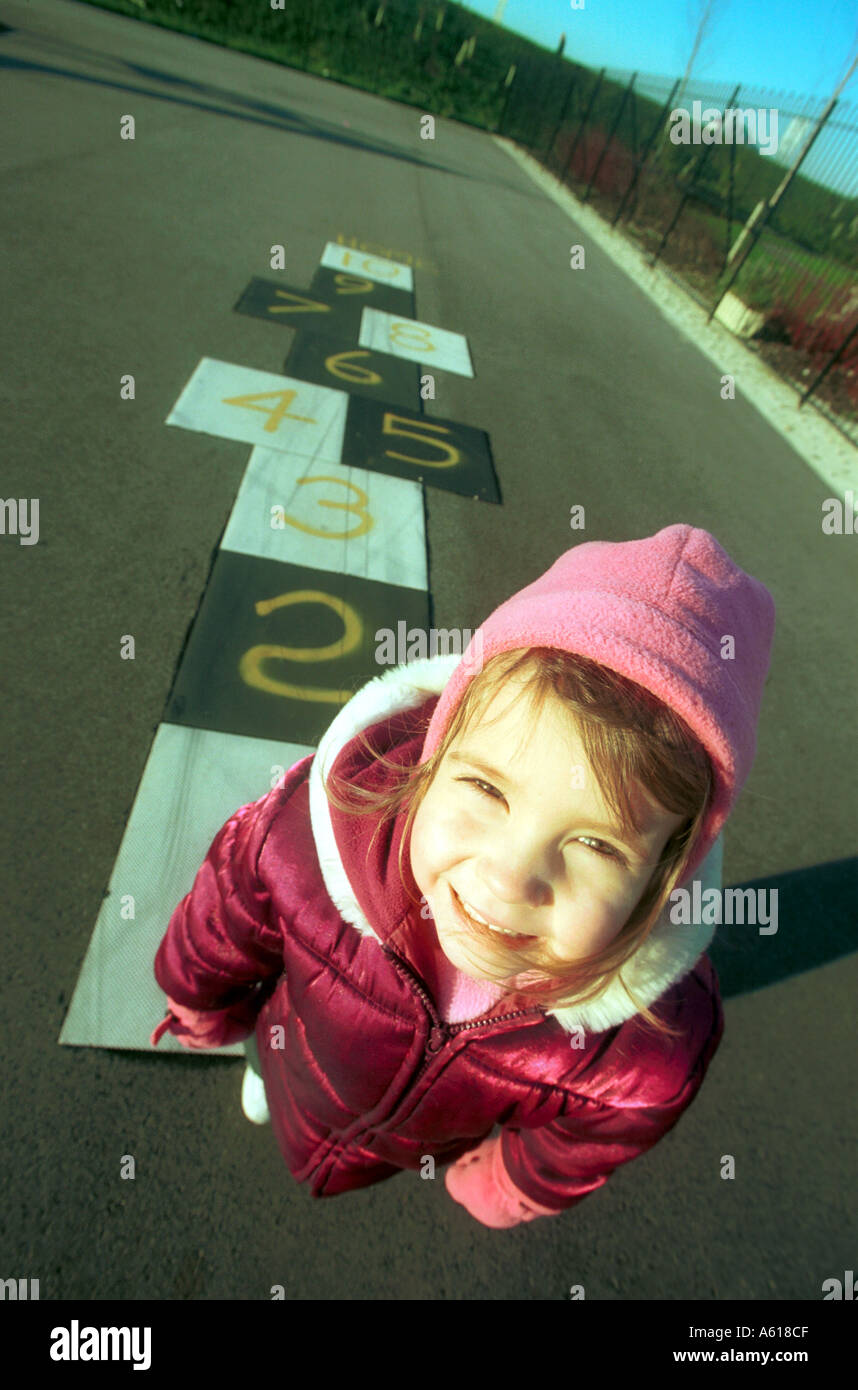 Ein junges Kind Spiel Himmel und Hölle in einen Kinderspielplatz Stockfoto
