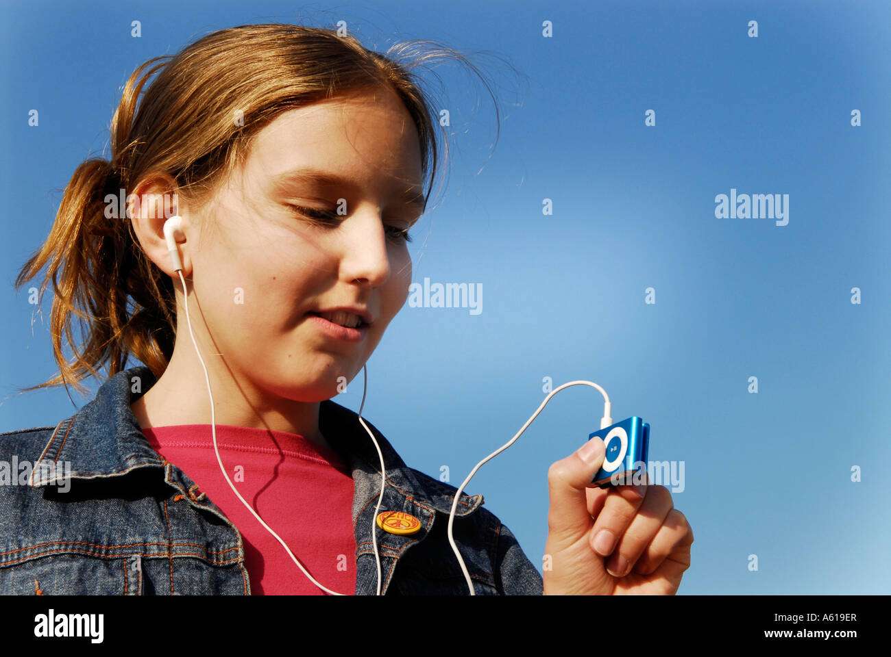 Mädchen hört Musik mit dem Apple IPod shuffle2 MP3 Player Stockfoto