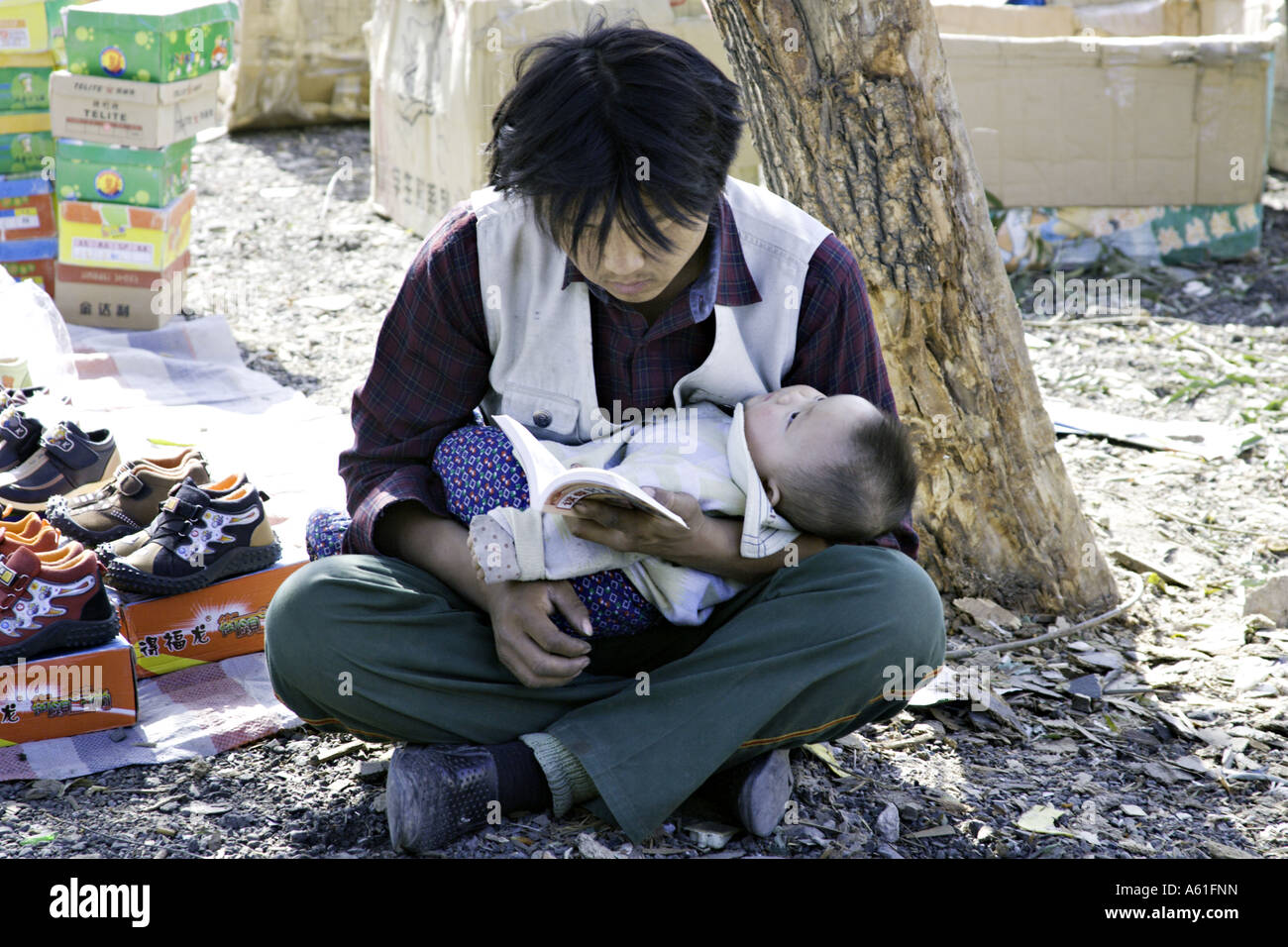 CHINA BEIJING jungen chinesischen Vater hält seinen kleinen Sohn, als er liest Stockfoto