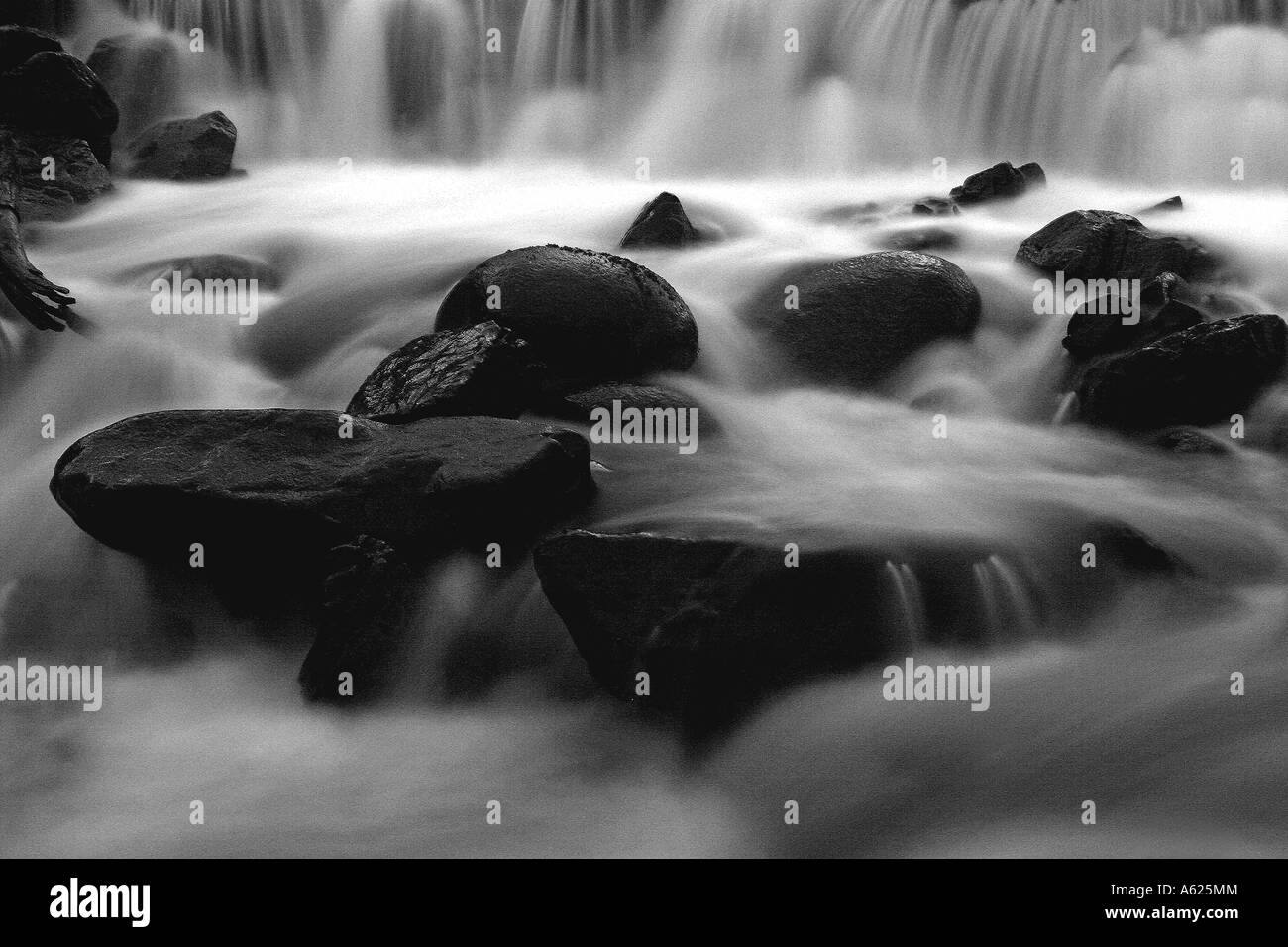 Schwarz / weiß Bild eines schottischen Flusses wie das Wasser, eingefangen in Zeitlupe, stürzt stromabwärts. Stockfoto