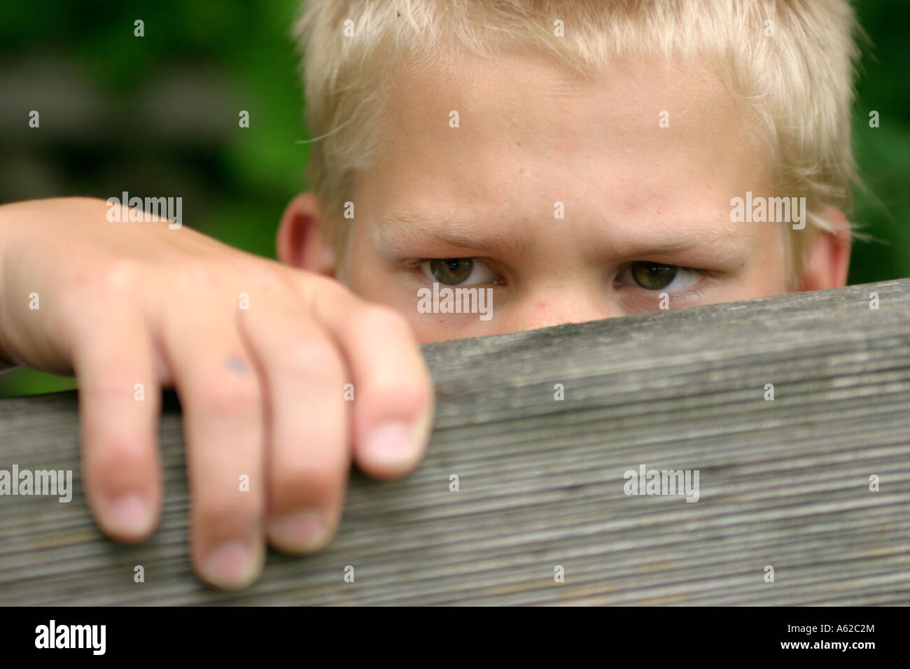 Porträt eines jungen fairen Blick über einen Zaun Angst Stockfoto