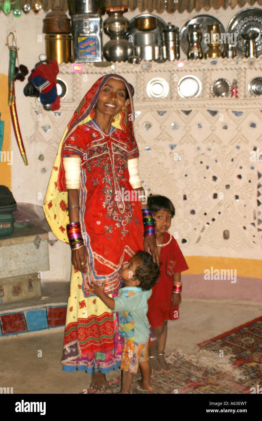 schöne indische, Banni tribal Frau und Kind in ihrer dekorierten Bhungas (tribal House) in der Nähe von Bhuj in Gujarat Stockfoto