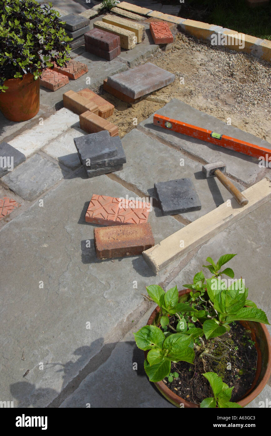 Aufbau einer Gartenterrasse Tools Wasserwaage und Pflastersteine Stockfoto