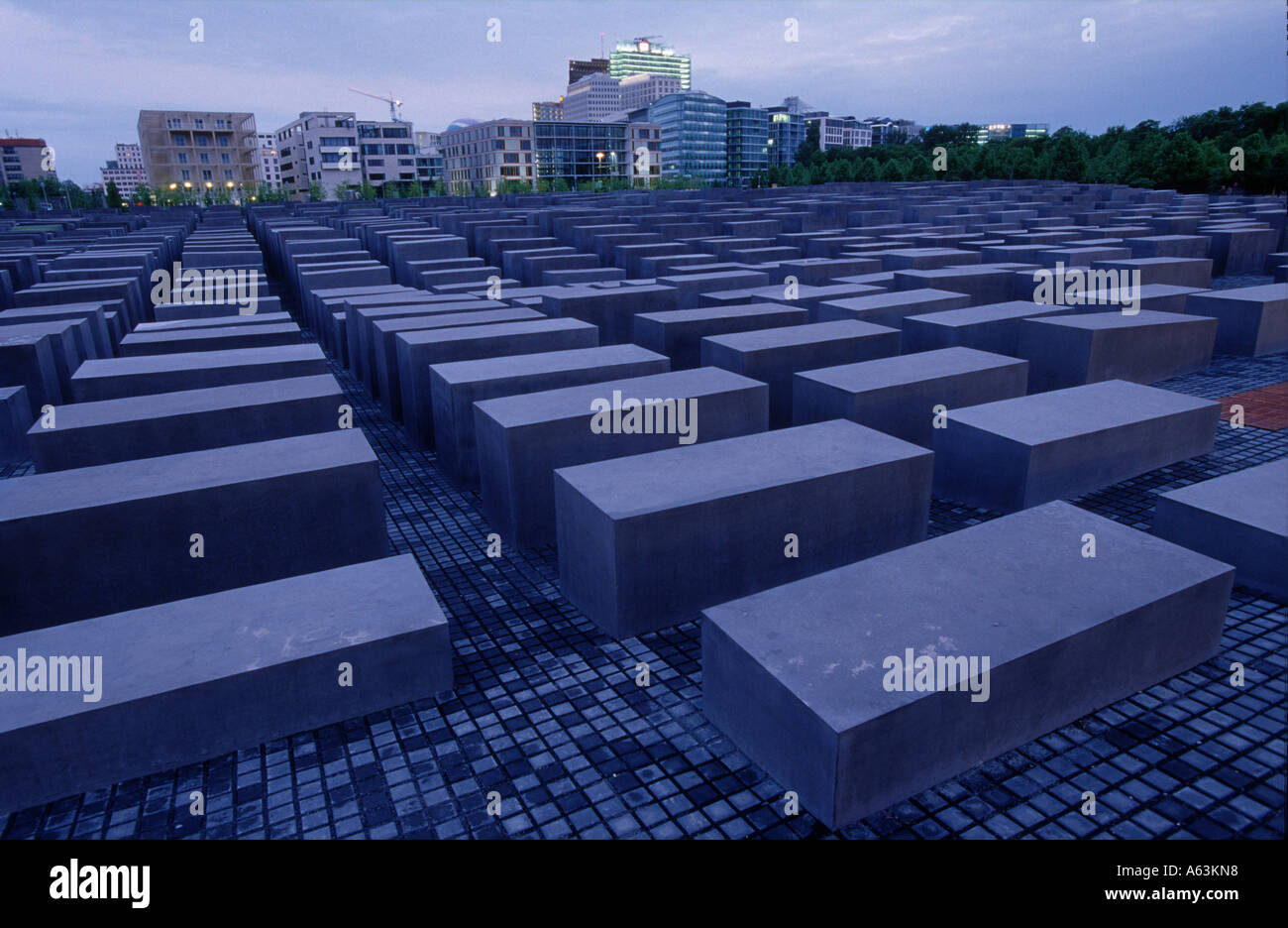 Beton-Stelen am Denkmal mit Gebäuden im Hintergrund, Holocaust-Mahnmal, Berlin, Deutschland Stockfoto