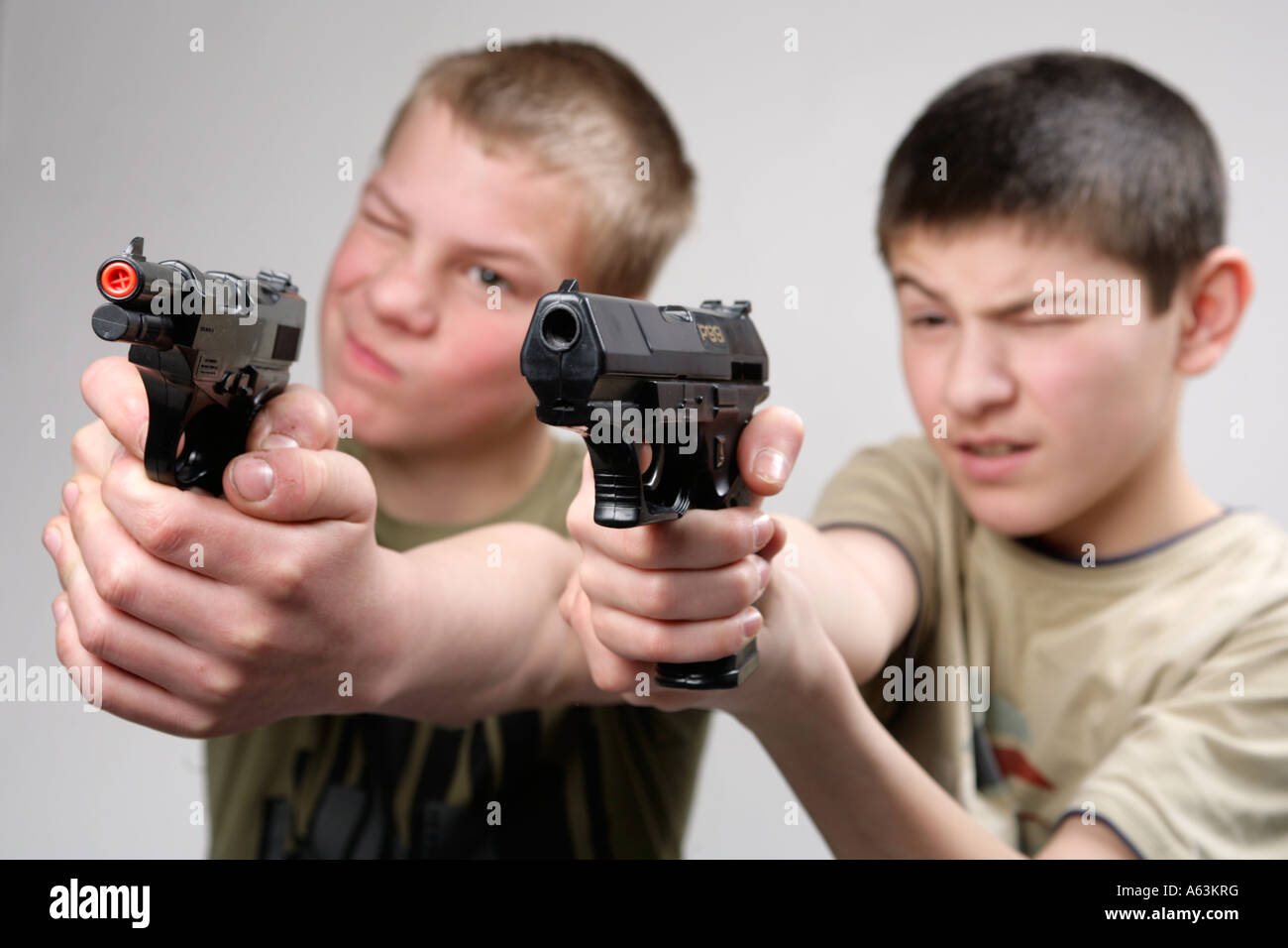zwei jungen, die ihre Spielzeugpistolen auf eine unsichtbare Feind gerichtet Stockfoto