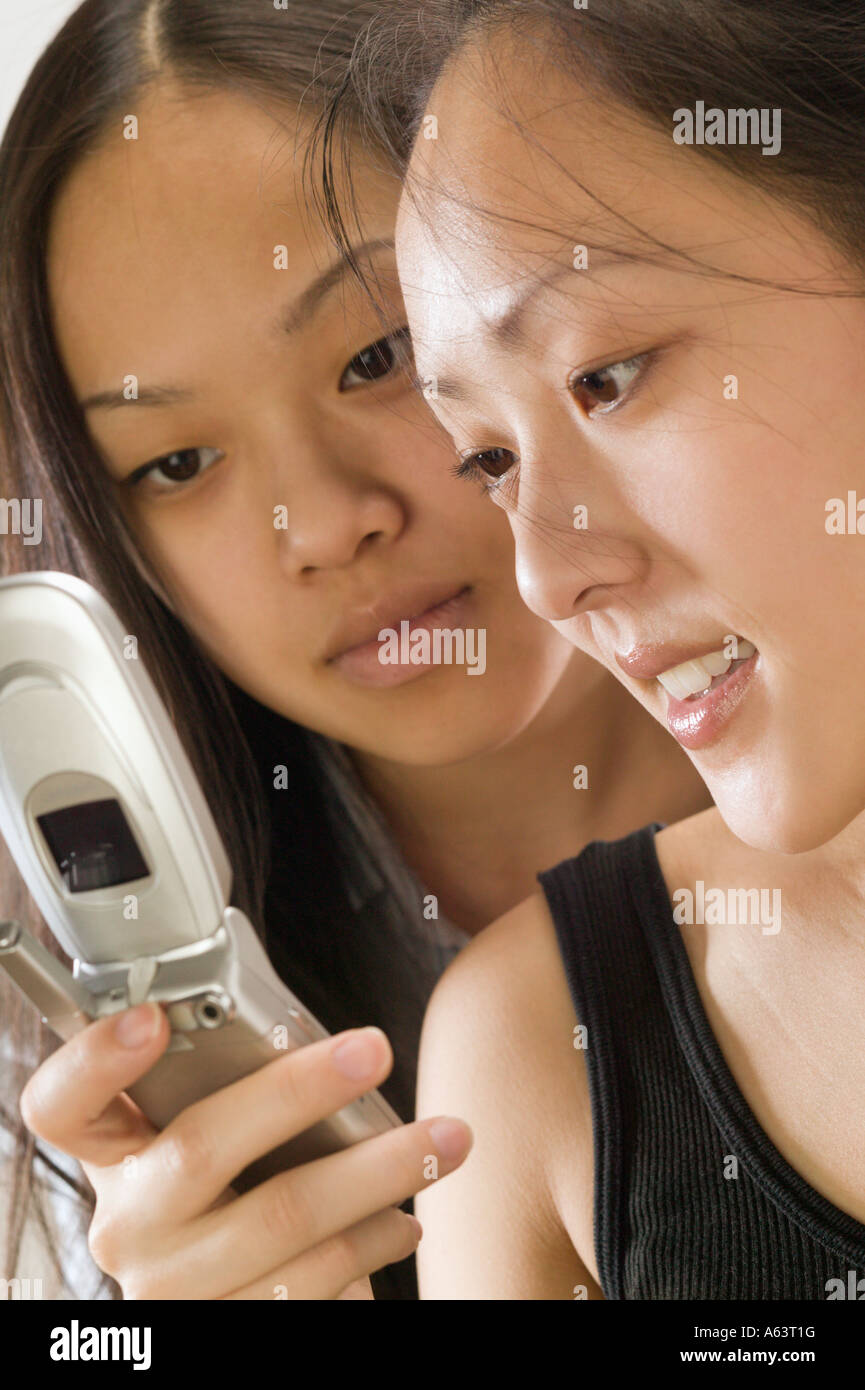 Zwei asiatische Frauen mit Handy Stockfoto