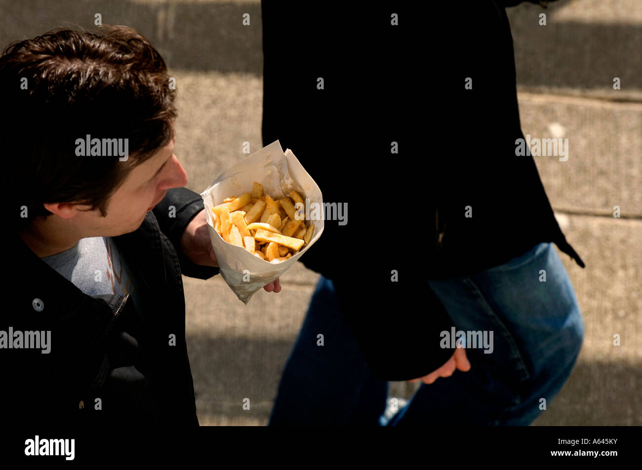 Ein Mann, der einen Sack Chips zum Mitnehmen hält. Bild von Jim Holden. Stockfoto