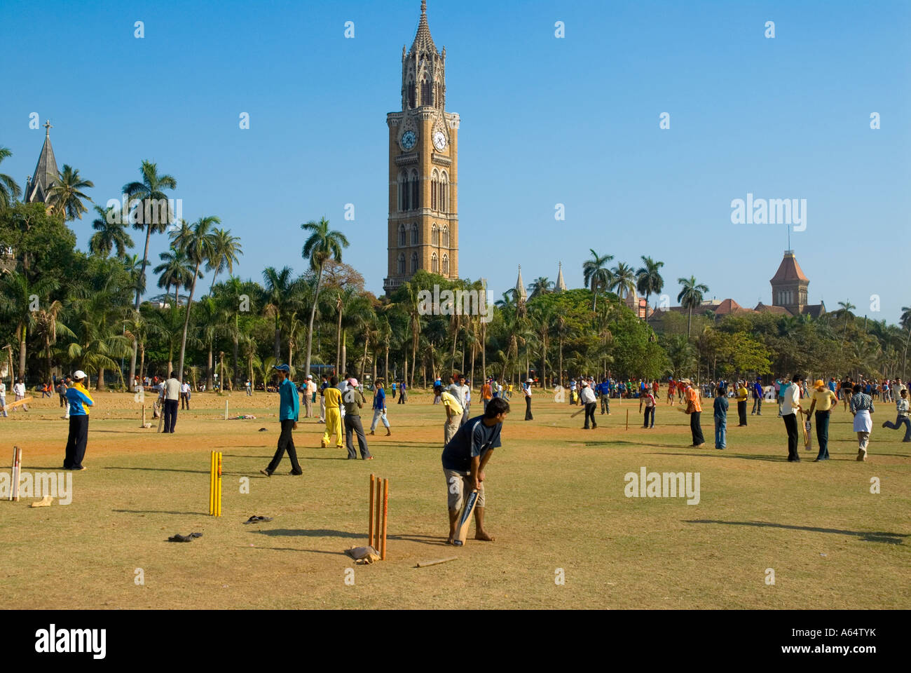 Menschen Sie spielen Cricket auf der ovalen Maiden mit dem Uhrturm im Hintergrund Mumbai Indien Stockfoto