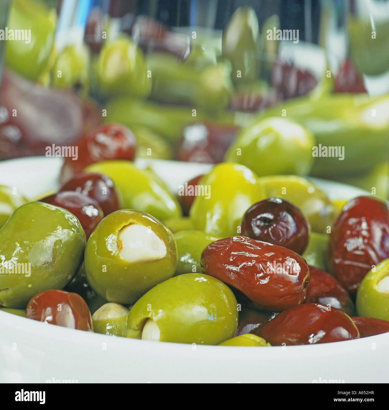 Eine Schüssel mit Oliven gefüllt mit ganzen Knoblauchzehen und Mandeln. Stockfoto