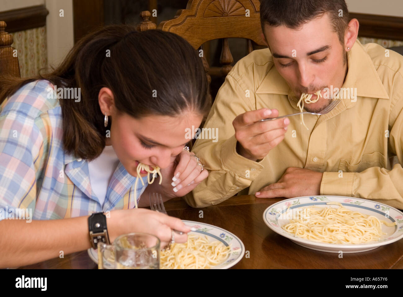 Das junge kaukasische Paar genießt gemeinsam Pasta in einer zwanglosen Umgebung. USA. Stockfoto