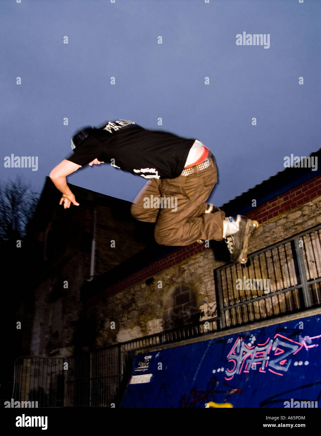 18 Jahre alte Männchen machen aggressive Inline skating Tricks in UK skatepark Stockfoto