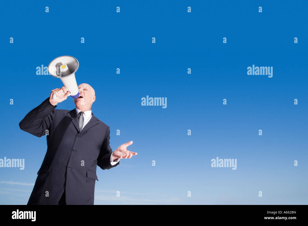 Busieness Mann mit Megaphon stehend gegen Himmel, niedrigen Winkel Ansicht Stockfoto