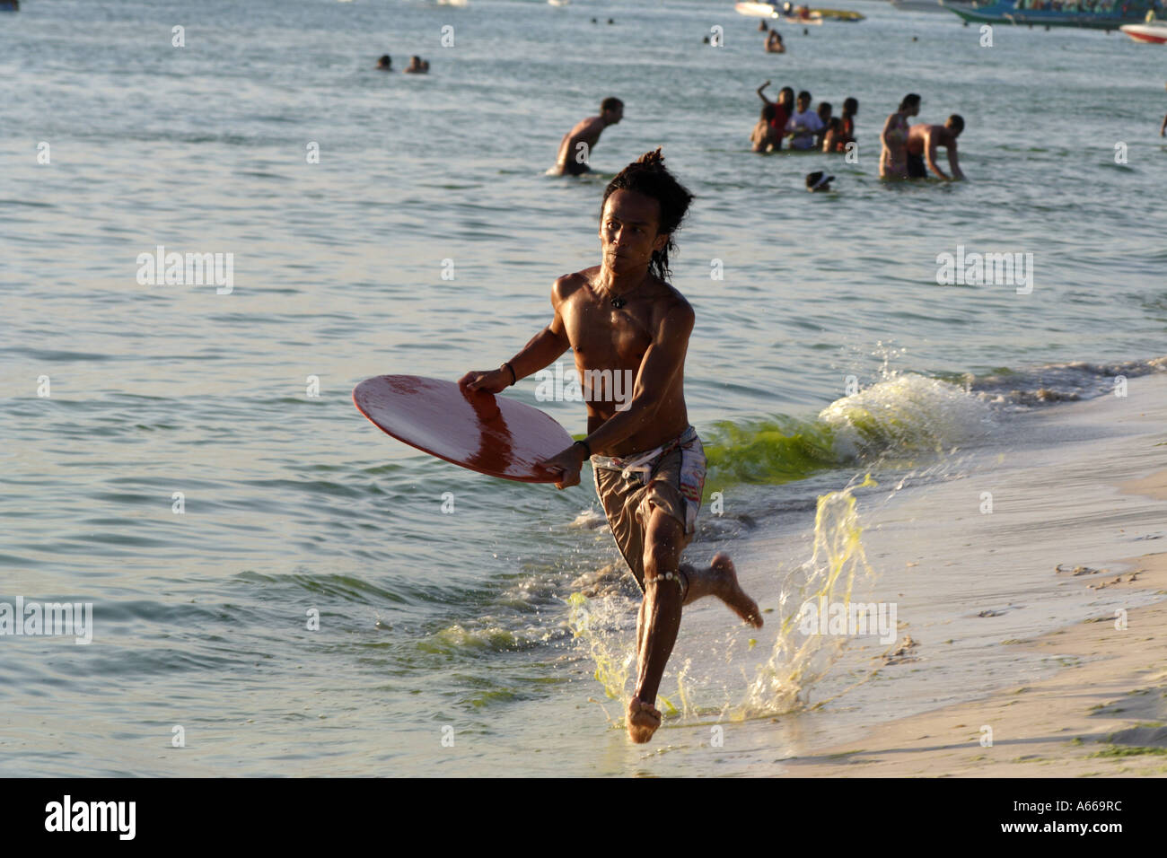 Junger Mann Ufer Surfen am Strand von Boracay, Philippinen Stockfoto