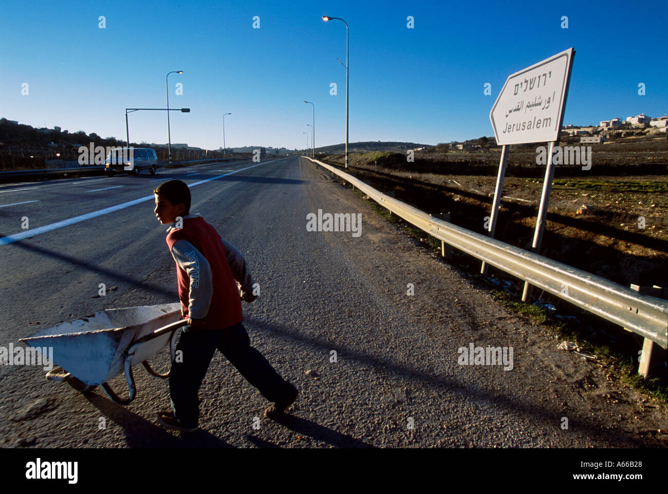Junge Palästinenser zu Rauschen mit einer Schubkarre musste ihr Gepäck Trog die Straßensperre nach Hebron tragen Stockfoto