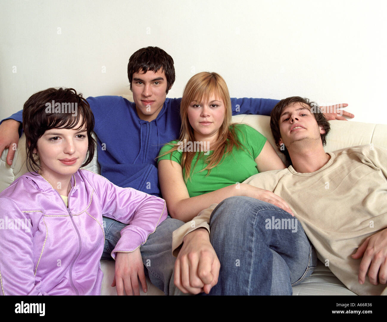 Porträt von vier Jugendlichen, die auf einer Couch sitzend Stockfoto