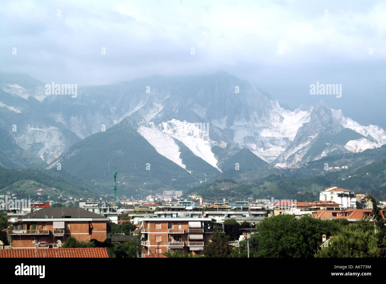 Wohngebiete unter einen Sommer Blick auf die weissen Steinbruch arbeiten in die Apuanischen Alpen, die berühmten Carrara Marmor für Skulptur & Gebäude Toskana Italien Stockfoto