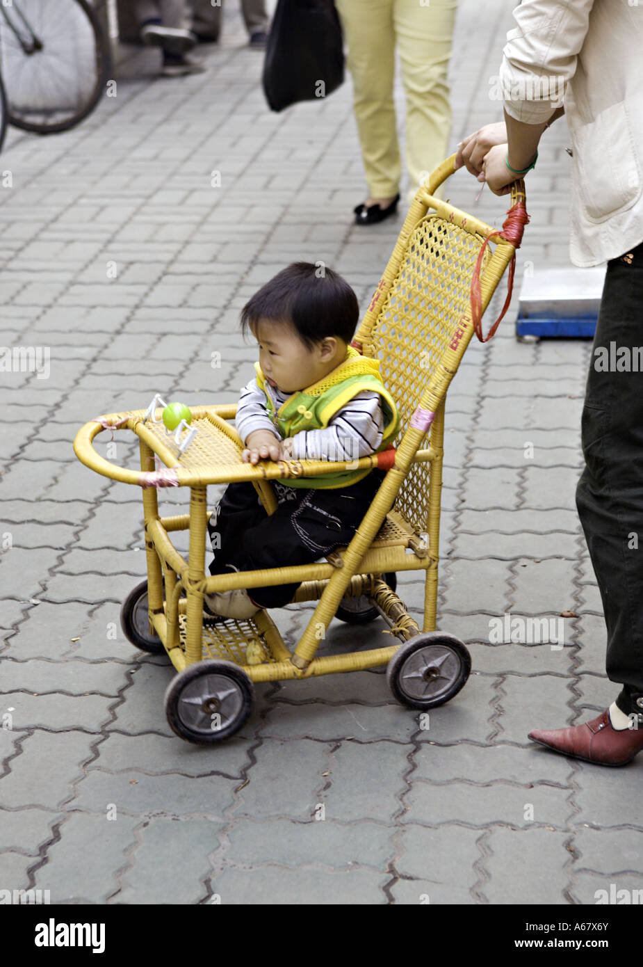 CHINA SHANGHAI Chinesisch baby Boy in einem traditionellen Bambus  Kinderwagen geschoben durch seine moderne junge Mutter Stockfotografie -  Alamy