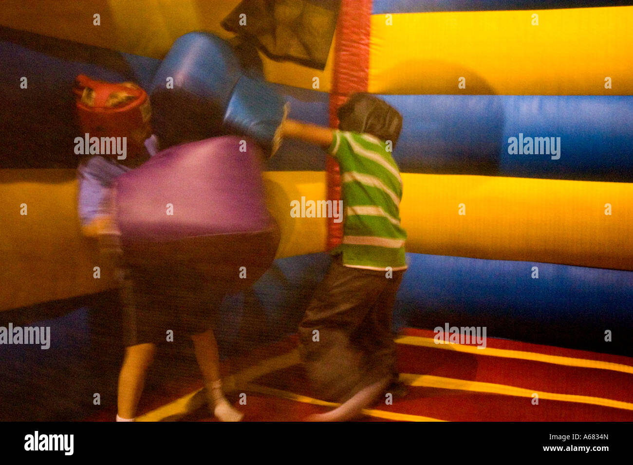 Jungen Alter 7 Boxen auf Pump It Up - Schlauchboot-Party-Zone - indoor-Entertainment für Kinder.  Burnsville, Minnesota USA Stockfoto