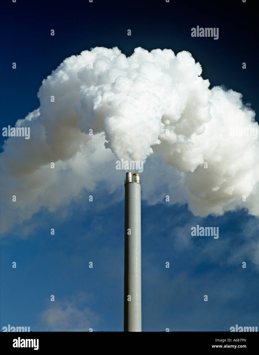 Ein Schornstein ausgießen Dichter weißer Rauch in einem klaren, blauen Himmel, UK Stockfoto